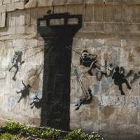 A mural attributed to the British graffiti artist Banksy is emblazoned on a wall in the Gaza Strip town of Biet Hanoun on Thursday. | REUTERS