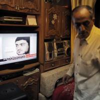 Said Musallam, an Israeli Arab whose son, Muhammad, is being held by Islamic State in Syria as an alleged spy, watches television reports about him in their East Jerusalem home on Thursday. Islamic State said on Thursday it was holding Muhammad Musallam, who had posed as a foreign fighter in order to spy for Mossad, an account denied by Israel and by his family, who said he had been kidnapped. | REUTERS