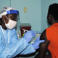A health worker injects a woman with an Ebola vaccine in Monrovia on Monday as Liberia carries out a trial of experimental Ebola vaccines involving thousands of volunteers as part of an effort to slow the spread of the deadly fever and prevent future outbreaks. | REUTERS