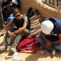 Reuters journalist Maria Golovnina rests with her colleagues at a checkpoint manned by anti-Gadhafi forces north of the besieged city of Bani Walid, Libya, in September 2011. Golovnina, Reuters bureau chief for Afghanistan and Pakistan who was widely loved and admired for her courage, compassion and professionalism, died in Islamabad on Monday. She was found collapsed and unconscious in the bureau and was rushed to a hospital, but medical teams were unable to save her. | REUTERS