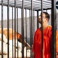 This still image made from video released by Islamic State group militants and posted on the website of the SITE Intelligence Group on Tuesday purportedly shows Jordanian pilot Lt. Mu\'ath al-Kaseasbeh standing in a cage just before being burned to death by his captors. The death of the 26-year-old pilot, who fell into the hands of the militants in December when his Jordanian F-16 crashed near Raqqa, Syria, followed a weeklong drama over a possible prisoner exchange. | AP