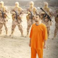 A man purported to be Islamic State captive Mu\'ath al-Kaseasbeh (front) is shown standing in front of armed men in a still image taken from an undated video of his execution. The video was released on social media on Tuesday. | REUTERS