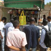 Sudanese men look at newspapers displayed at a kiosk in Khartoum on Monday. Sudanese security officers seized the print runs of 13 newspapers in one of the most sweeping crackdowns on the press in recent years, Journalists for Human Rights said. | AFP-JIJI