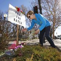 A woman leaves a bouquet of flowers Monday in Prescott, Arizona, the hometown of 26-year-old Kayla Jean Mueller. The death of Mueller was confirmed by her parents and the Obama administration Tuesday. | AP