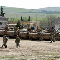 Turkish armored vehicles that took part in an operation inside Syria sit near the Mursitpinar border crossing in the southeastern town of Suruc, Sanliurfa province, Monday. A Turkish military operation to rescue 38 soldiers guarding a tomb in Syria surrounded by Islamic State militants was launched to counter a possible attack on them, presidential spokesman Ibrahim Kalin said on Monday. The action, which involved tanks, drones and reconnaissance planes as well as several hundred ground troops, was the first of its kind by Turkish troops into Syria since the start of the civil war there nearly four years ago. | REUTERS