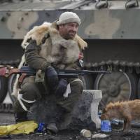 A Russian-backed rebel rests as in Debaltseve, Ukraine, on Friday. After weeks of relentless fighting, the embattled Ukrainian rail hub of Debaltseve fell Wednesday to Russia-backed separatists, and the rebels reported taking hundreds of soldiers captive. | AP