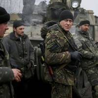 Members of Ukraine\'s armed forces stand next to their tank on a road not far from Debaltseve, in the east of the country, on Sunday. | REUTERS