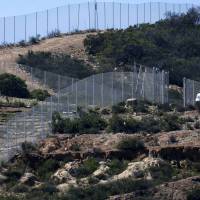 A U.S. border patrol officer sits in his vehicle along the border with Mexico near San Ysidro, California on Wednesday. U.S. Senate leaders took a tentative step on Tuesday that could avert a partial shutdown of the Department of Homeland Security, but it was unclear if House Speaker John Boehner and restive conservatives would support a new concession to Democrats. | REUTERS