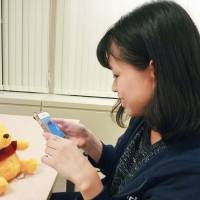 A Mercari Inc. staffer in Tokyo explains how to use the app to sell unwanted goods. | KYODO