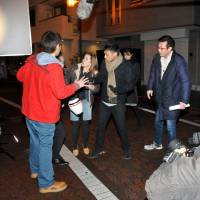Actors shoot a scene for the upcoming movie \"Mirai Shutter\" in Ota Ward\'s Umeyashiki district on Jan. 22. The movie is being produced by the nonprofit organization WUP Film, which is trying to revitalize the Kamata neighborhood\'s once-thriving movie industry. | YOSHIAKI MIURA