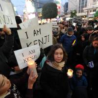 Julia Maeda (center), a friend of slain journalist Kenji Goto, participates in a mourning event at Hachiko square in Tokyo\'s Shibuya Ward on Sunday. | YOSHIAKI MIURA