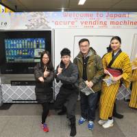 Tourists pose for a photo with JR Water Business Co. staff dressed in ninja and kimono outfits, in front of an Acure smart vending machine at JR Akihabara Station on Thursday. | YOSHIAKI MIURA