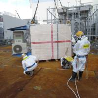 This handout picture taken by Tokyo Electric Power Co. on Monday shows a measuring device of cosmic rays, to be used to look inside crippled reactors, being installed at Tepco’s Fukushima No. 1 nuclear plant at Okuma, Fukushima Prefecture. The device will use muons to check fuel debris inside the reactors. Tepco starts using cosmic rays to grasp condition inside damaged reactors