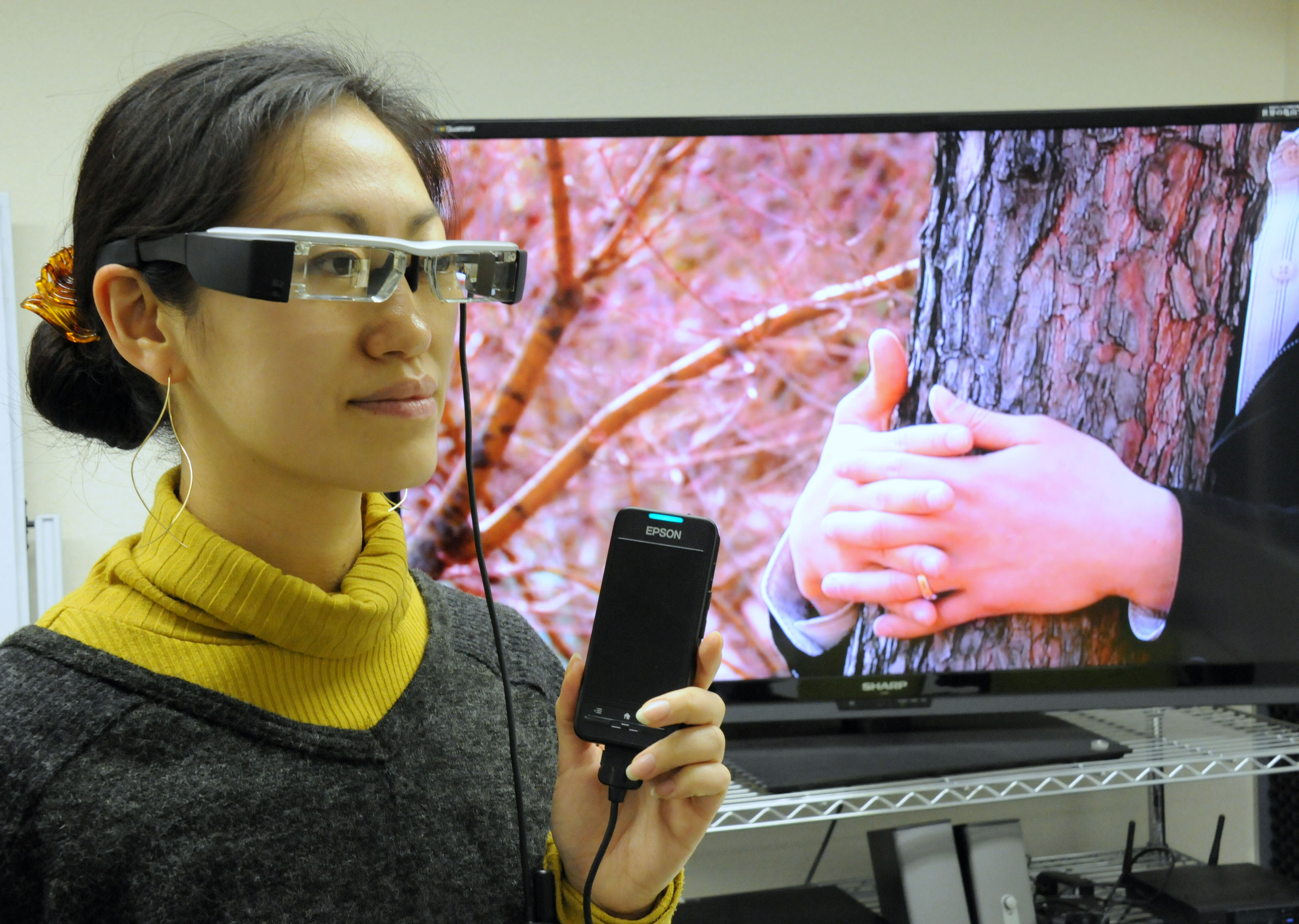 People who are deaf or blind can participate in a movie screening by wearing a special pair of UDCast glasses that are connected to an iPhone. | SATOKO KAWASAKI