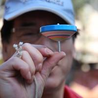 In a spin: Hanegi Park regular Takeo Shigehara, 65, is a master at controlling koma (spinning tops) as well as the smaller beigoma tops. | KIT NAGAMURA