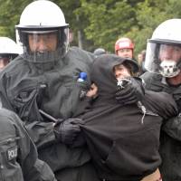 Riot police arrest a demonstrator during an environmental protest in Rostock, Germany, in June 2007.  | BLOOMBERG