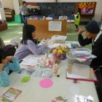 Community leader Katsumi Sawaguchi (right) talks with children at the Philia Cafe run by the Catholic charity Caritas Japan in Kamaishi, Iwate Prefecture.  | KERRY SHIOYA