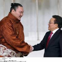 Fitting honor: Mongolian President Tsakhiagiin Elbegdorj congratulates yokozuna Hakuho on Tuesday in Ulan Bator, where the sumo legend received the Mongolian equivalent of Japan\'s People\'s Honor Award. | KYODO