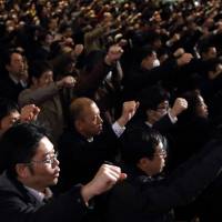 Labor union members raise their hands during an event held by the Japanese Trade Union Confederation in Tokyo on Feb. 5. | BLOOMBERG