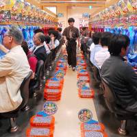 Customers try their luck at a Pachinko parlor in Tokyo in June 2007. | BLOOMBERG