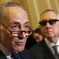 U.S. Senate Minority Leader Harry Reid (right) and Sen. Chuck Schumer talk to the media in Washington in February. Reid has endorsed Schumer to succeed him in the leadership role. | REUTERS