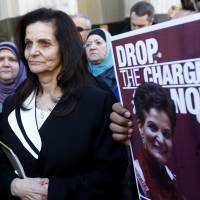 Palestinian activist Rasmieh Yousef Odeh (center) stands outside the federal courthouse after her sentencing in Detroit on Thursday. Odeh was sentenced to 18 months in prison for immigration fraud for failing to tell U.S. authorities that she had been imprisoned in Israel for a 1969 supermarket bombing that killed two people. Chicago activist gets prison term for immigration crime of lying about Israel bombing convictions