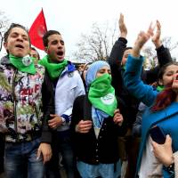 Participants at the World Social Forum being held in Tunis march down a boulevard near the Bardo museum during a ceremonial reopening of the museum Tuesday. The museum held the ceremonial reopening a week after gunmen claiming alliance with Islamic State killed 20 foreign tourists in an attack aimed at wrecking the country\'s vital tourism industry. | REUTERS