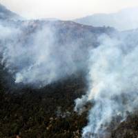 Smoke columns rise over mountains on the Conguillo National Park, Chile. Sunday. Massive wildfires raging in drought-stricken southern Chile have wiped out hundreds of plant species, and are now threatening animal life as well, officials warned. \"We are witnessing a massive environmental catastrophe\" in southern Chile, Accion Ecologica chief Luis Mariano Rendon told AFP. | AFP-JIJI