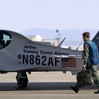 A pilot walks past a Lufthansa light aircraft trainer at the Airline Training Center Arizona (ATCA) in Goodyear, Arizona, on Thursday. U.S. media on Thursday reported that Andreas Lubitz, a young German co-pilot who locked himself in the cockpit of Germanwings Flight 9525 and flew it into a mountain Tuesday, had spent some months training at the Lufthansa-owned pilot training facility in Arizona. The ATCA told Reuters it was not commenting on the reports. | REUTERS