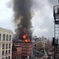 Fire shoots from the roof of a building after it collapsed and burst into flames in New York City\'s East Village as seen in this picture taken by Scott Westerfeld on Thursday. Rescuers from the Fire Department of New York were headed to the location, which was on Second Avenue and East 7th Street in Manhattan, an FDNY spokeswoman said. | REUTERS