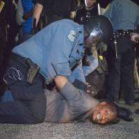 A police officer arrests a protester outside the Ferguson, Missouri, police department on Wednesday. | REUTERS