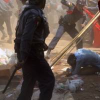 A police officer beats a student protester in Letpadan, 140 km north of Yangon on March 10. | AP
