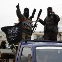 Members of al-Qaida\'s Nusra Front drive in a convoy through one of the villages that they claimed to have seized from Syrian rebel factions in the southern countryside of Idlib last December. | REUTERS