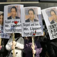 Conservative South Korean activists hold portraits of U.S. Ambassador Mark Lippert near the U.S. Embassy in Seoul on Friday during a rally expressing hope for his quick recovery. | AP