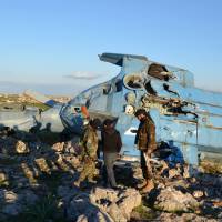 Nusra Front fighters inspect a helicopter that belongs to forces loyal to Syria\'s President Bashar Al-Assad after it crashed in Jabal al-Zawiya in the southern countryside of Idlib on Sunday. The Syrian military helicopter crashed in northwestern Syria on Sunday and at least four of its crew were captured by rebels, according to a monitoring group. Video footage on social media showed a helicopter crashing in the distance. Photographs posted showed one of the crew apparently executed on the spot and an injured pilot taken by rebels from the wreckage. | REUTERS