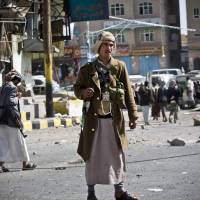 Houthi Shiite rebels guard a street leading to the presidential palace in Sanaa in January. | AP