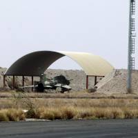 A fighter jet is parked under a hangar Saturday on the tarmac of Sanaa International Airport after the third day of Saudi-led coalition airstrikes against Huthis. | AFP-JIJI