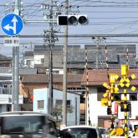 The green signal from this special traffic light is hard to see from a distance, forcing drivers to slow down before reaching the intersection. | CHUNICHI SHIMBUN