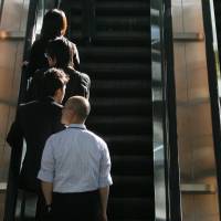 Commuters stand on the left of escalators in Tokyo. Osakans use the right-hand side, but an ordinance now under consideration would force them to change.  | BLOOMBERG