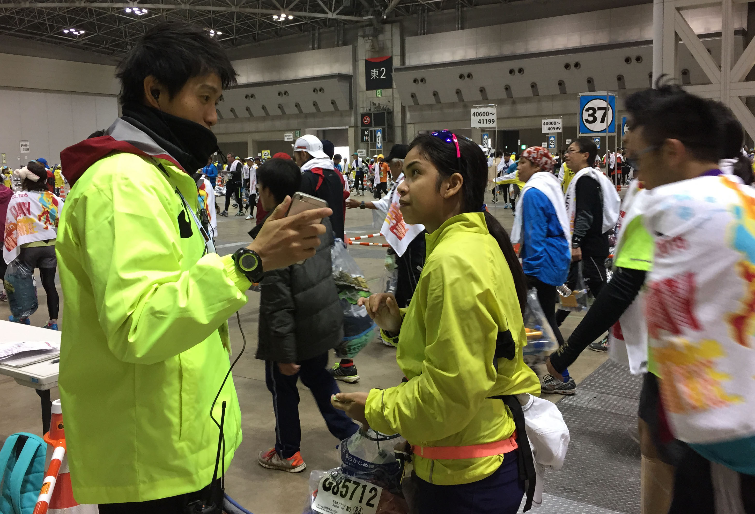 A member of the support staff for Tokyo Marathon 2015 communicates with a foreign participant using a translation application on his smartphone on Feb. 22.  | TOKYO MARATHON FOUNDATION