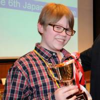 Sean Fogerty, a student attending Robert D. Edgren High School in Misawa, Aomori Prefecture, poses with his trophy after winning the 6th Japan Times Bee in Tokyo on Saturday. For the championship word, the 13-year-old correctly spelled \"snood,\" a net or fabric bag for confining a woman\'s hair pinned or tied on at the back of the head. | SATOKO KAWASAKI