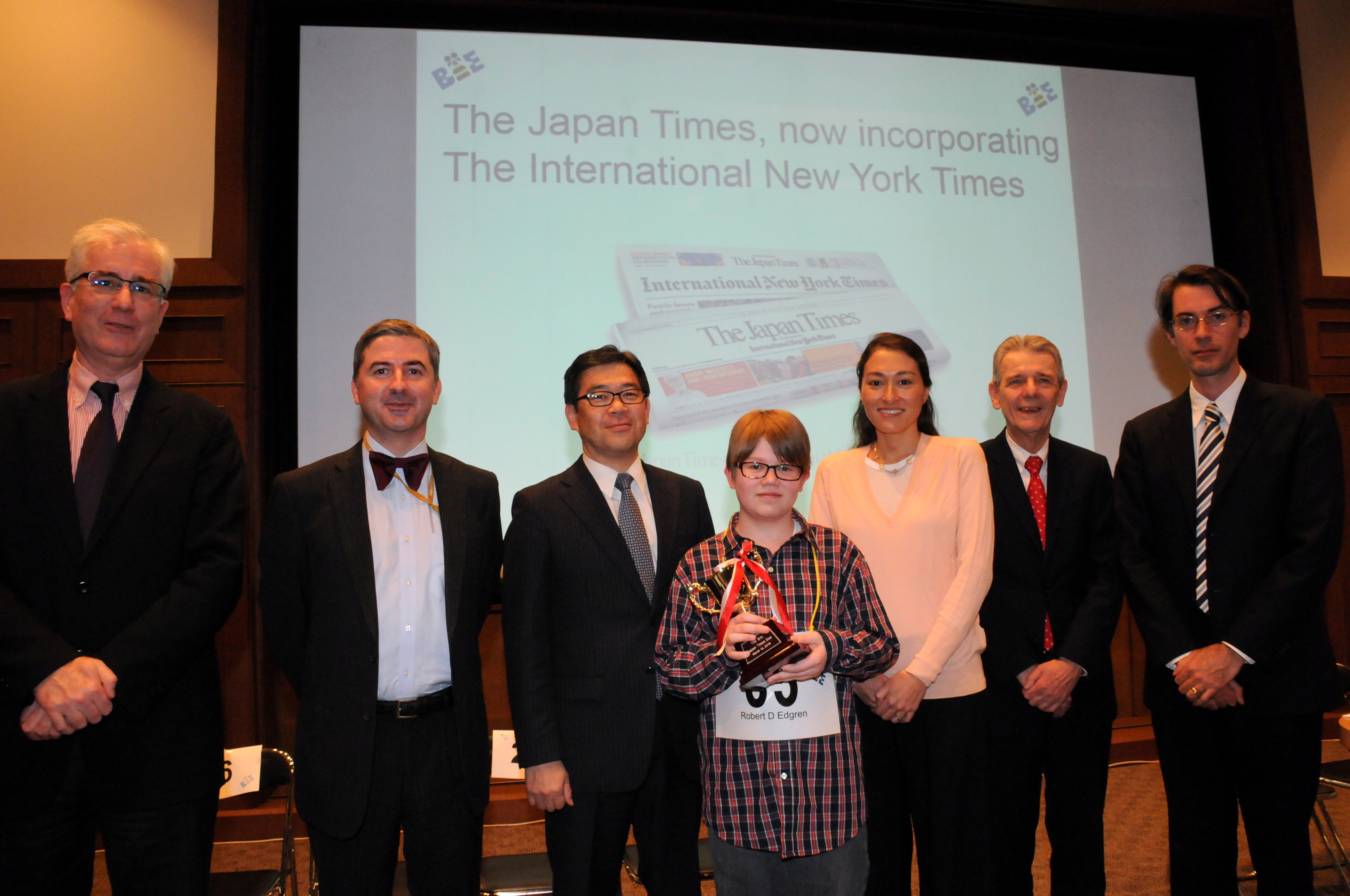 Sean Fogerty (center), the 13-year-old winner of the 6th Japan Times Bee, poses with (from left) spelling judge Steve McClure, master of ceremonies Marc Davies, The Japan Times President Takeharu Tsutsumi, spelling judge Teru Clavel, pronouncer James Tschudy and The Japan Times Managing Editor Edan Corkill. | SATOKO KAWASAKI