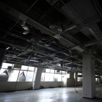 Air ducts and power lines dangle from the ceiling of a commercial building, owned by auto-parts maker Murata Spring Co., in an industrial park on the old factory site of Panasonic Corp. in Utsunomiya, Tochigi Prefecture, on Feb. 13. | BLOOMBERG