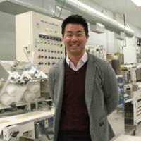 Kenshiro Uki, 28, general manager at Sun Noodle\'s New Jersey factory, poses at the plant last month. He wants to expand regional ramen culture in the United States. | AYAKO MIE