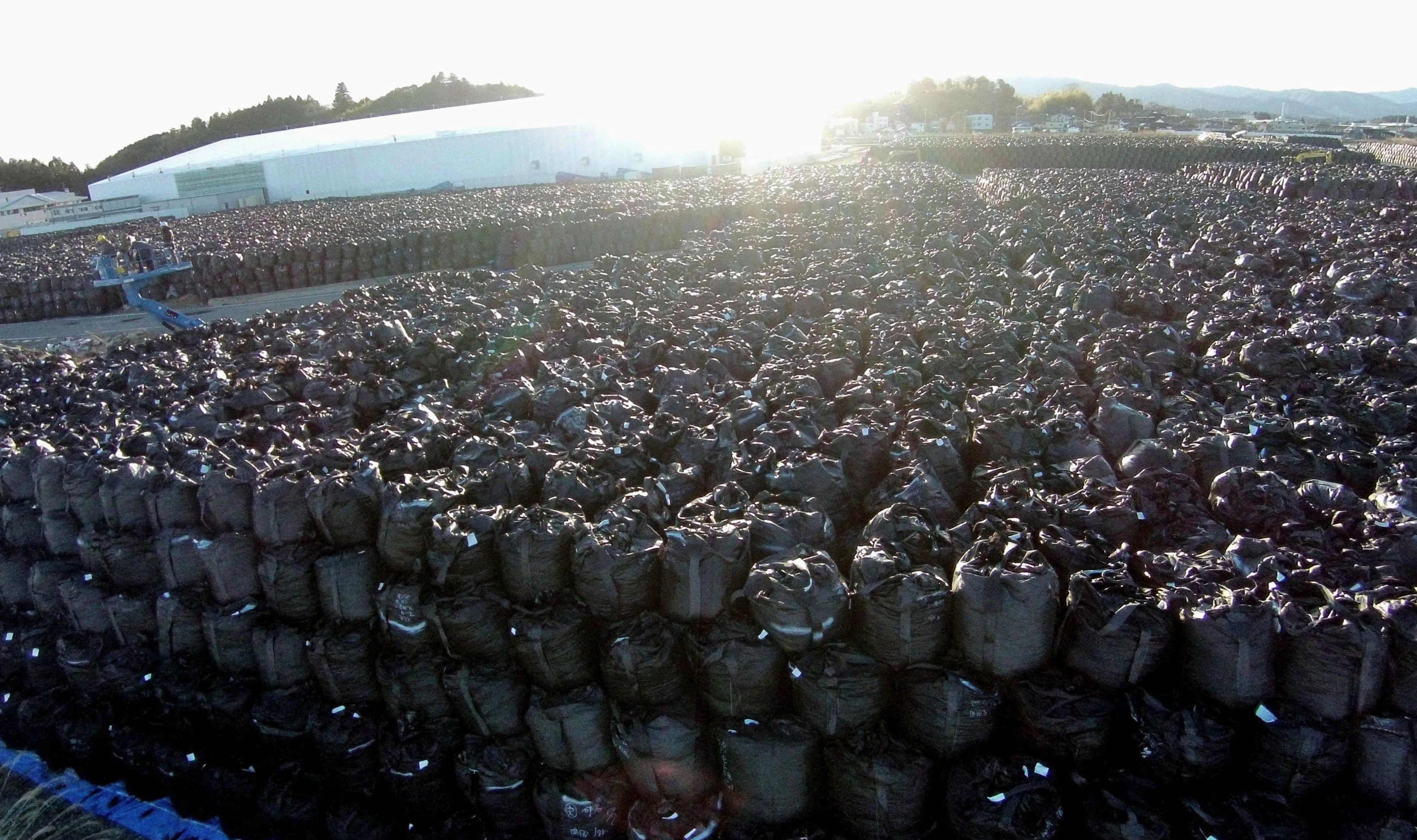 Bags of radioactive waste are seen piled up at a temporary storage site in Tomioka, Fukushima Prefecture, on Wednesday. Four years after the nuclear disaster began, a final disposal site for tainted debris it created has yet to be designated. | KYODO