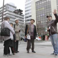 Justin Velgus (right), an American living in Sendai, guides a group of tourists around the city on March 7 ahead of the United Nations World Conference on Disaster Risk Reduction, which starts Saturday. | KYODO