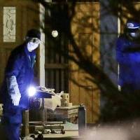 Police conduct an investigation outside a small family-run factory in Takaraduka, Hyogo Prefecture, Tuesday evening after the owner of the factory and his wife were found fatally stabbed. | KYODO