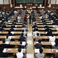 Students wait for their entrance examination to start at the University of Tokyo\'s Hongo campus on Feb. 25. | KYODO
