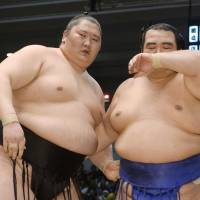 On to the next one: Ichinojo (left) and Kotoshogiku catch their breath following their bout on the sixth day of the Spring Grand Sumo Tournament on Friday in Osaka. Ichinojo won the match. | KYODO