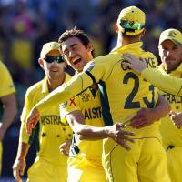 On top of the world: Australia\'s Mitchell Starc (center) celebrates with captain Michael Clarke after dismissing New Zealand\'s Luke Ronchi for a duck during the World Cup final on Sunday. | REUTERS